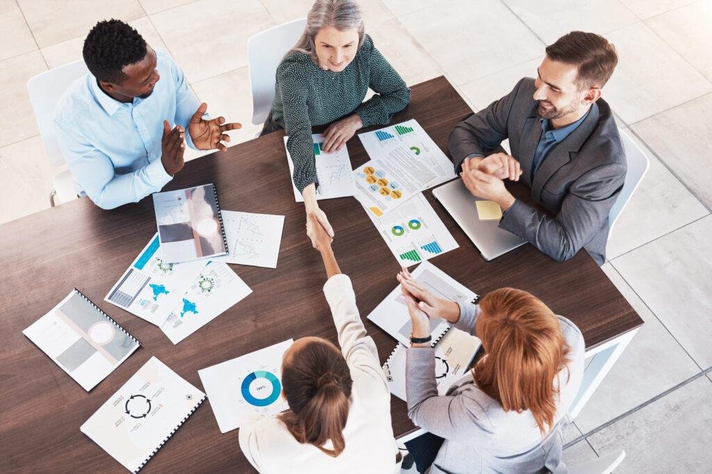 Executives sealing new ai digital marketing deal with a client with handshake across conference table